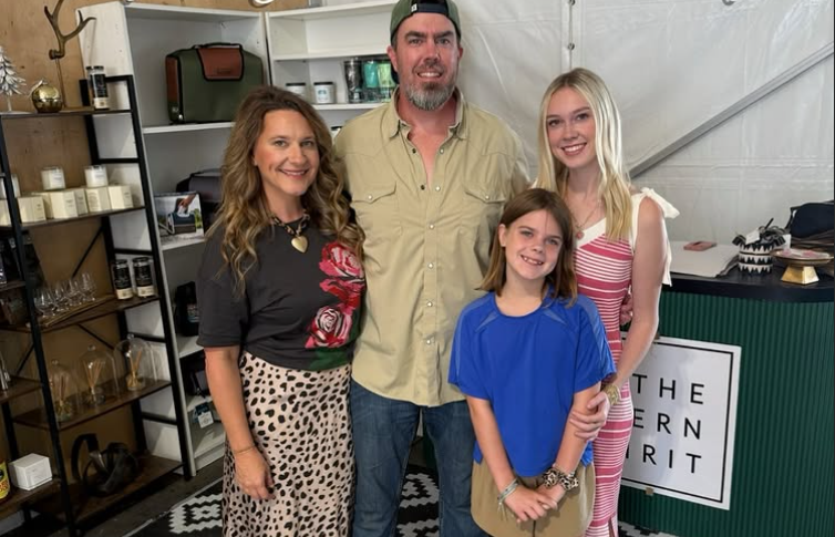 Family of four posing together in a store setting with shelves and decor in the background.