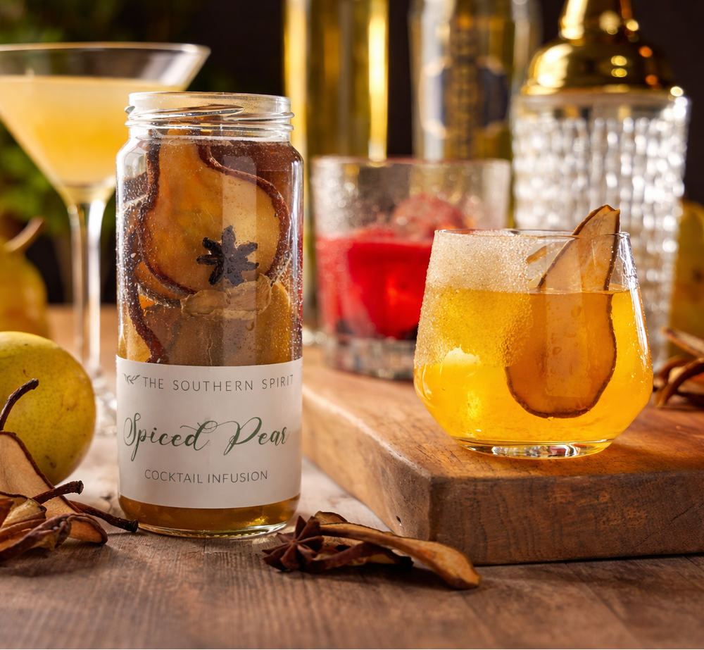 Bottle of 'The Southern Spur' Spiced Pear cocktail infusion with a glass of the drink on a wooden surface.